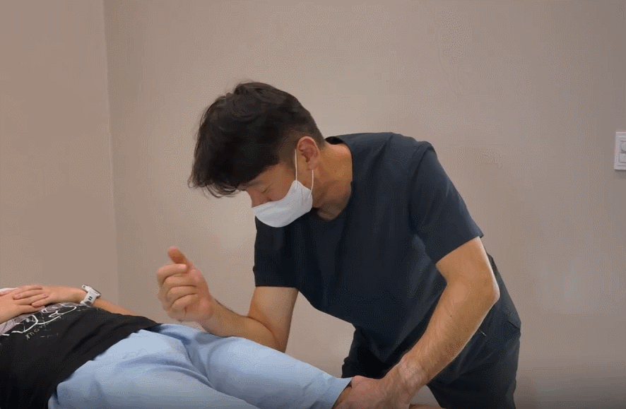 의료진이 환자의 엉덩이와 허벅지 주변 움직임을 확인하는 진료 장면